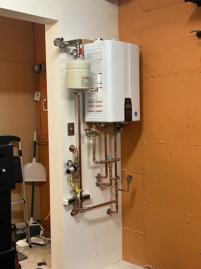 Plumbing technician inspecting water heater connections in Thonotosassa
